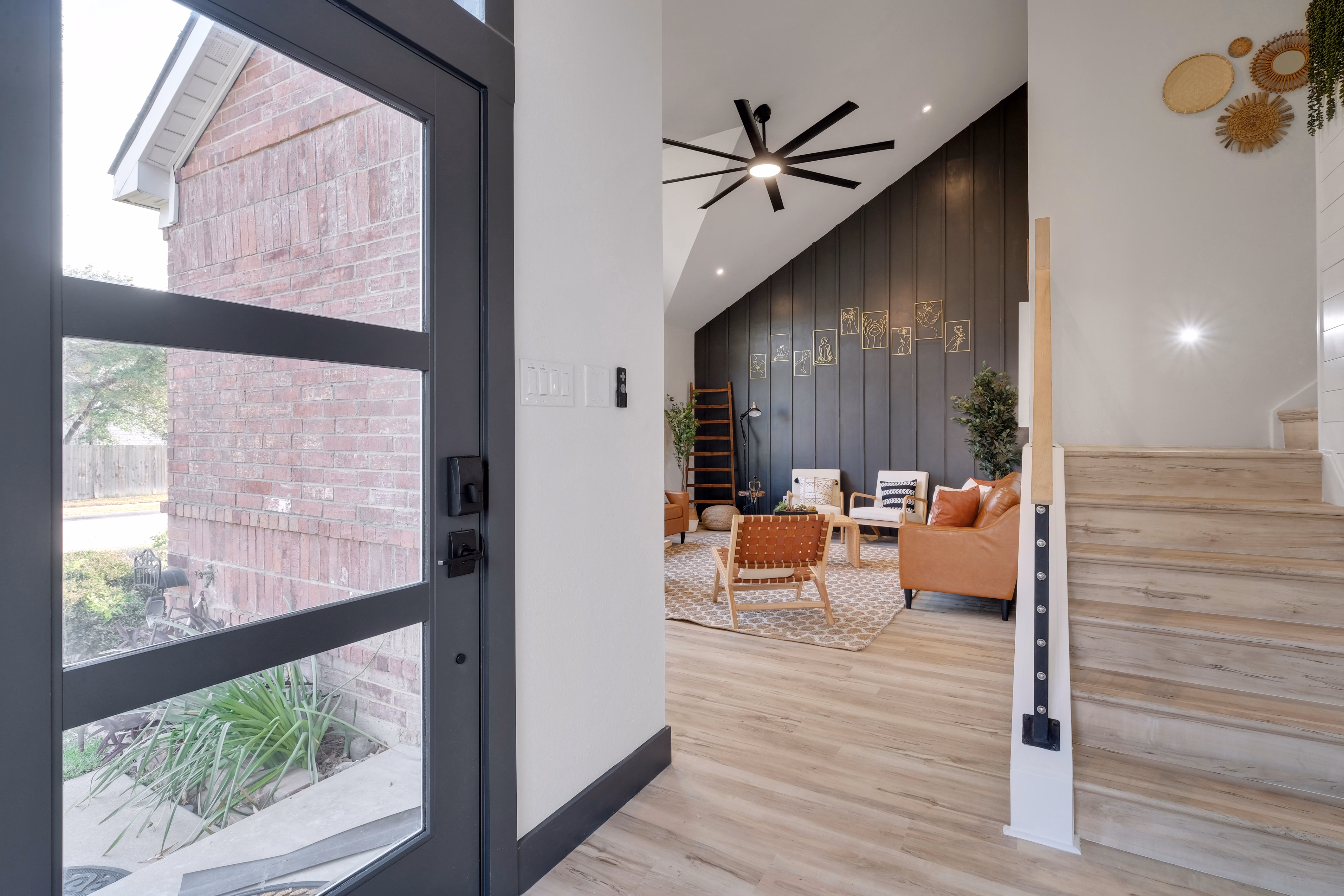 Entry view through front door into vaulted living room with stairs.