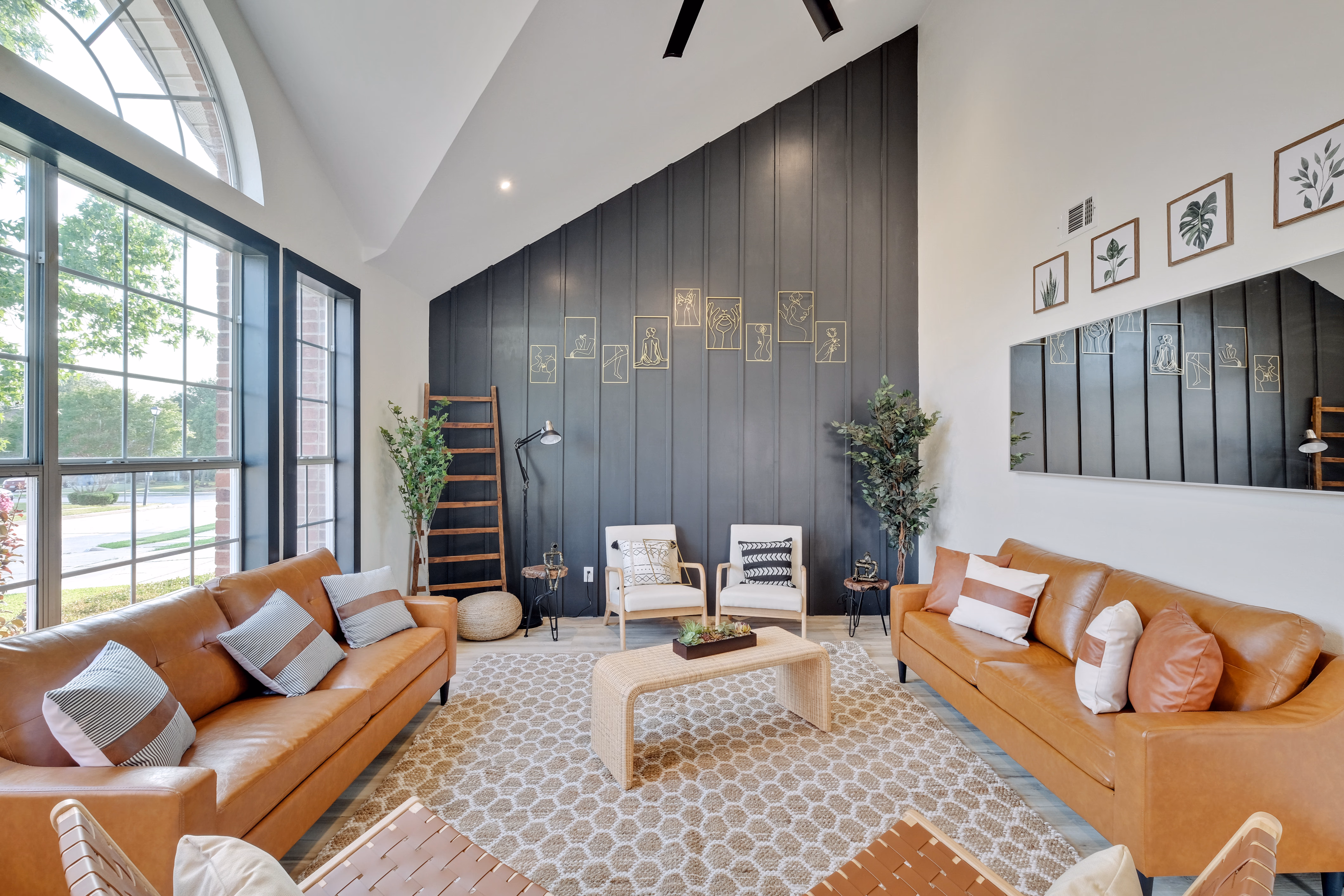 Living room — twin leather sofas facing dark accent wall art.