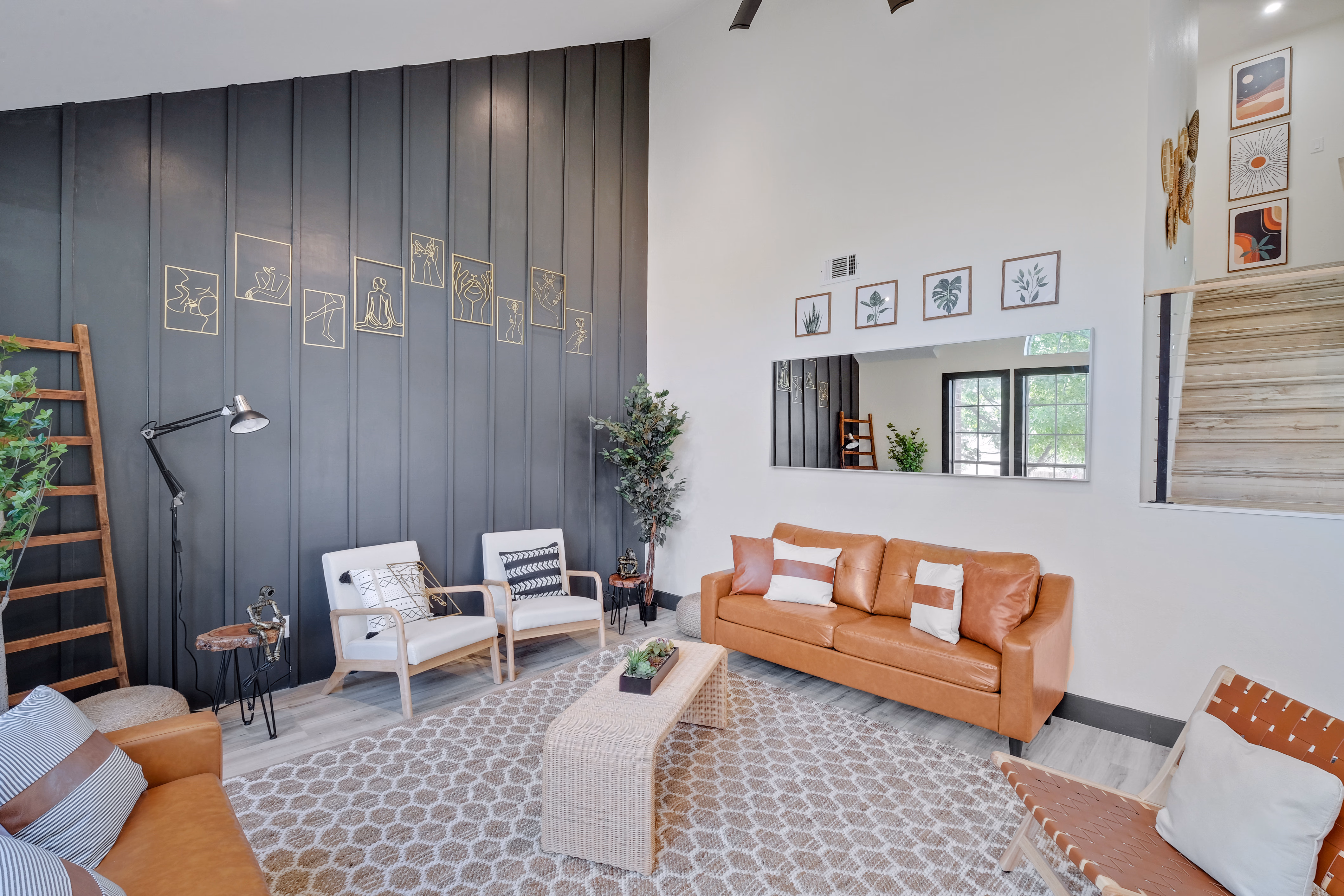 Living room — accent wall with framed art, mirror, leather seating.
