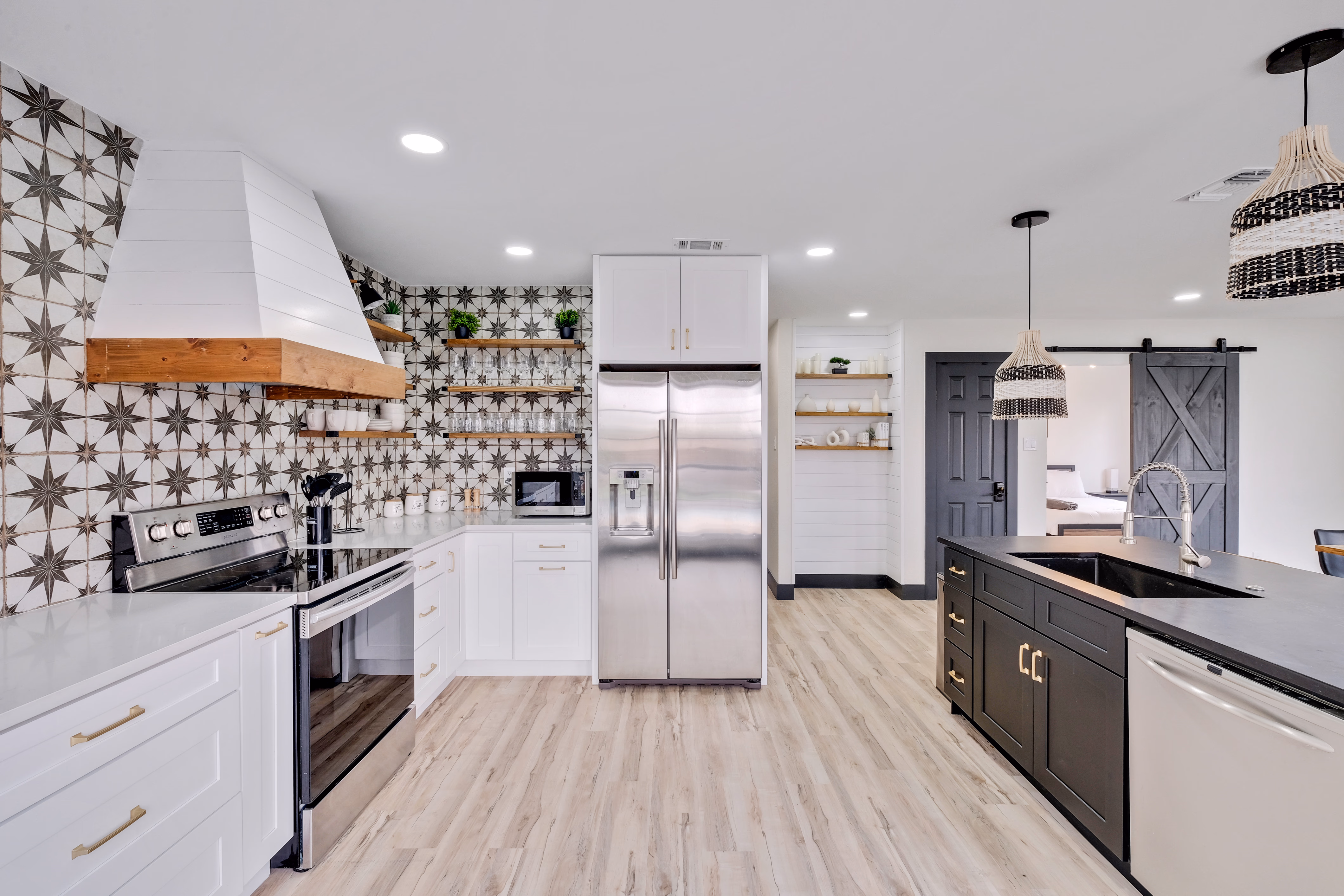 Kitchen — range hood, open shelving, twin islands view.